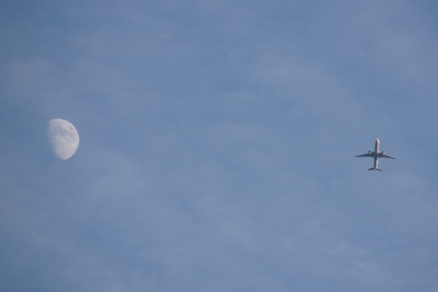 月のそばを飛ぶ飛行機