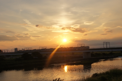 日の入前の夕日と多摩川を渡る東急線